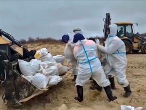 Rescuers and volunteers work to clean up tons of fuel oil that spilled out of two storm-stricken tankers