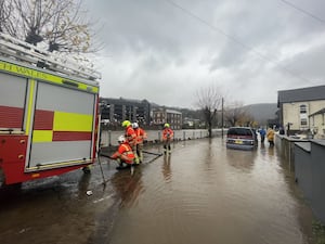 Firefighters pumping water from a street by the River Taff in Pontypridd, Wales, following flooding