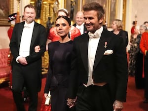 David and Victoria Beckham make their way along the East Gallery to attend the state banquet