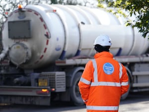 A worker watches as a Thames Water tanker pumps out excess sewage