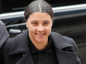 Sam Kerr smiles as she walks into court