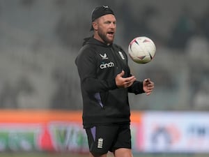 Brendon McCullum throws up a football