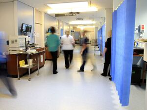 Blurred images of people walking in a hospital ward