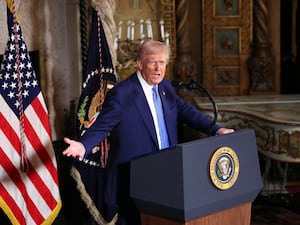 US President Donald Trump next to an American flag speaking at Mar-a-Lago in Florida