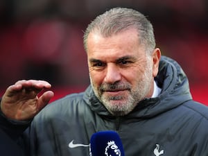 Ange Postecoglou smirks as he raises his hand