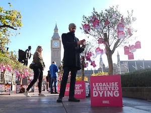 A man reads a ‘dying wish’, tied to a tree near the Houses of Parliament by a group of terminally ill people and bereaved relatives, in support of the Terminally Ill Adults (End of Life) Bill