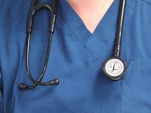 A stethoscope hanging around the neck of a doctor wearing scrubs