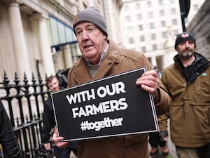 Jeremy Clarkson holding a sign supporting farmers