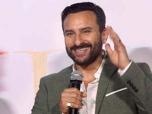 Saif Ali Khan smiling while speaking into a microphone