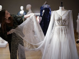 A woman next to a custom-made gown worn by Angelina Jolie