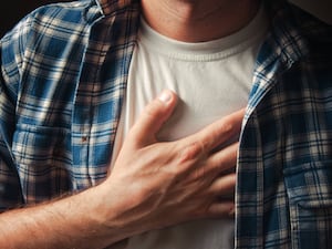 A man clutches his chest in pain