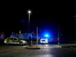 Police cars behind a police cordon, at the scene in Woolwich, south east London where a 14-year-old boy has been stabbed to death on a Route 472 bus.