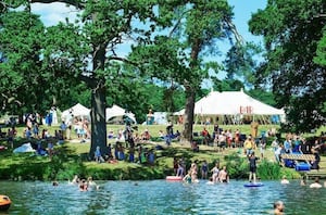 The beautiful lake at ALSO Festival in Compton Verney where people paddleboard, wild swim and do yoga