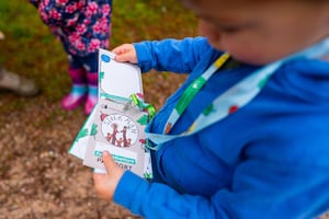 A young child looking at a Stick Man trail passport