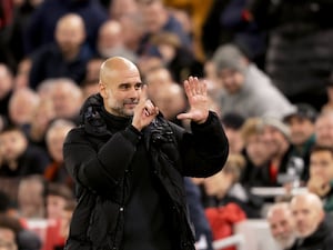 Pep Guardiola holds up six fingers, one for each Premier League title he has won, as he responds to the Liverpool fans at Anfield