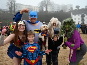 People take part in the annual Tenby Boxing Day swim dressed as superheroes