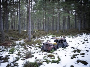 An abandoned vintage car in snow