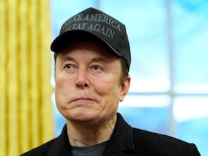 Elon Musk listens during an event in the Oval Office with President Donald Trump