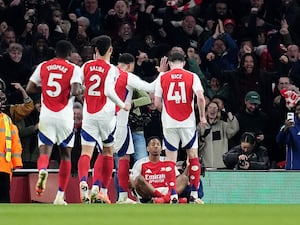 Myles Lewis-Skelly is surrounded by his team-mates as he celebrates his goal