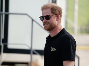 The Duke of Sussex wearing a black polo shirt and dark sunglasse