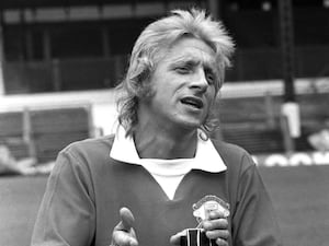 Denis Law fools around with a camera during a Manchester United press photocall at Old Trafford.