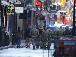 Military personnel walk down Bourbon Street in New Orleans