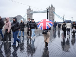 People walk during a rain shower in central London