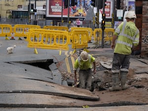 Workmen in a sinkhole