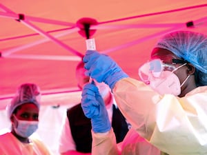 A health worker prepares to administer a vial of a vaccine against the Sudan strain of Ebola, during a trial at Mulago Referral Hospital in Kampala, Uganda