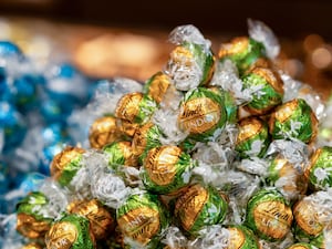 Lindt chocolates in gold and green wrappers, with blue-wrapped sweets in the background