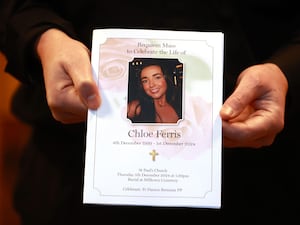 A mourner holds the order of service for the funeral of Chloe Ferris