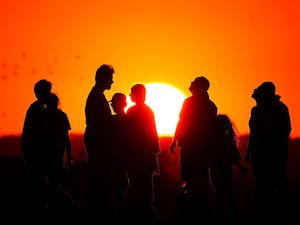 People watch the sunset during a heatwave