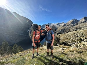 Hikers Aziz Ziriat, left, and Sam Harris in front of some mountains