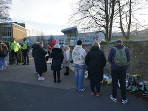 Police officers and floral tributes outside All Saints Catholic High School (PA)