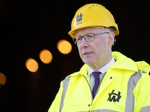 Headshot of John Swinney in hard hat and hi-voz jacket