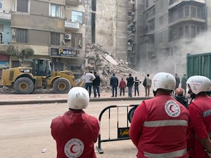 Rescuers looking at a collapsed building