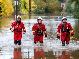 Firefighters walk through floodwaters while responding to a rescue call in Sonoma County, California