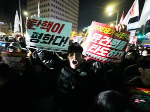 A man shouts to demand South Korean President Yoon Suk Yeol to step down in front of the National Assembly in Seoul, South Korea, Wednesday, Dec. 4, 2024