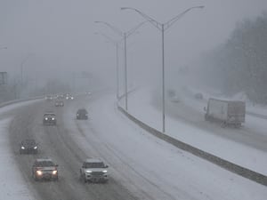 Vehicles drive along a highway during a winter storm