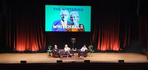 Hilary and Michael Whitehall took the stage with an image of their popular podcast