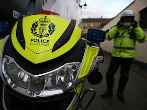 A Police Scotland officer next to a motorbike