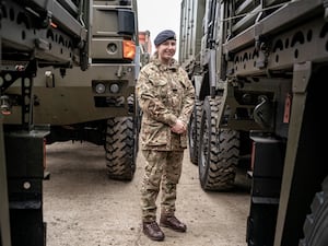 Private Erica Simpson next to military vehicles