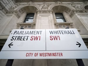 A street sign giving directions to Parliament Street and Whitehall in London