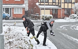 Charlie and Oliver Leath, aged 12, play in the snow in Perton