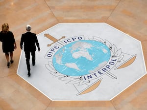 People walk on the Interpol logo at the organisation's HQ in Lyon, France