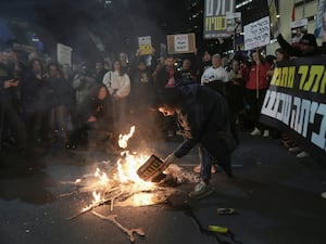 Demonstrators light a fire during a protest