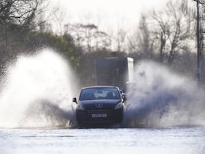 A vehicle drives through flood water