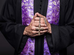 A vicar holding a cross