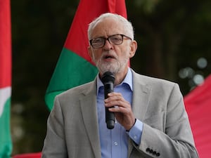 Jeremy Corbyn speaking into a microphone during a Palestine Solidarity Campaign rally