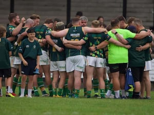 Aberavon Fighting Irish players and staff stand in circle arm in arm